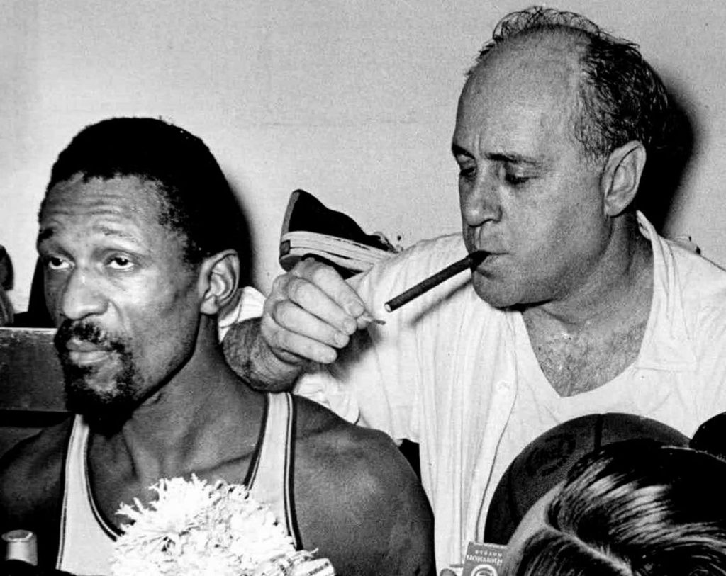 Red Auerbach enjoys a victory cigar post game.