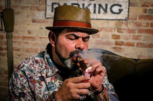 Man lighting a cigar in a smoking lounge