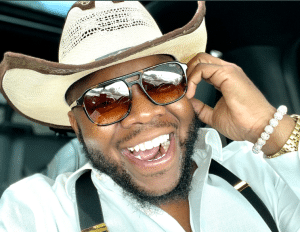 Calvin Jenkins smiling while wearing a cowboy hat and shades.