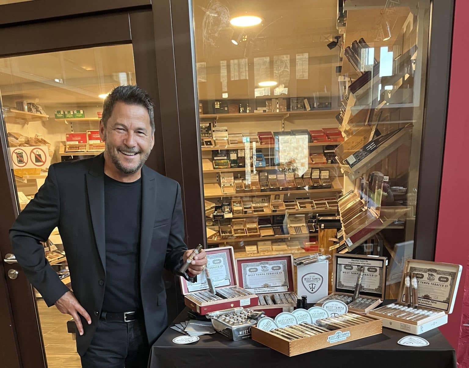 Rick Rodriguez pictured next to several boxes of premium cigars.